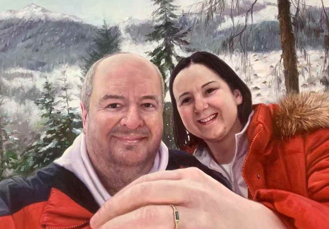 A couple in red outerwear together in a snowy mountain setting.