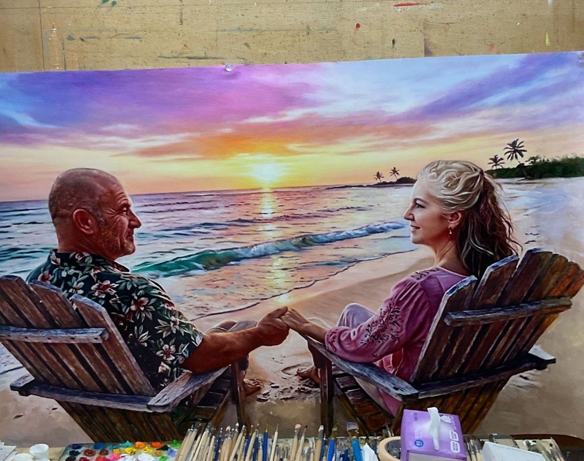 Hand-painted picture of an older couple in deck chairs on a beach, holding hands with the sun setting over the sea.
