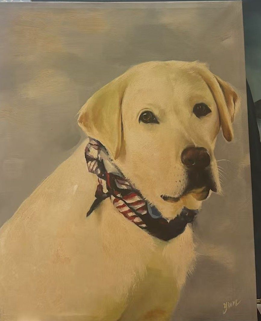 A yellow Labrador wearing a patterned neck scarf against a warm neutral background.