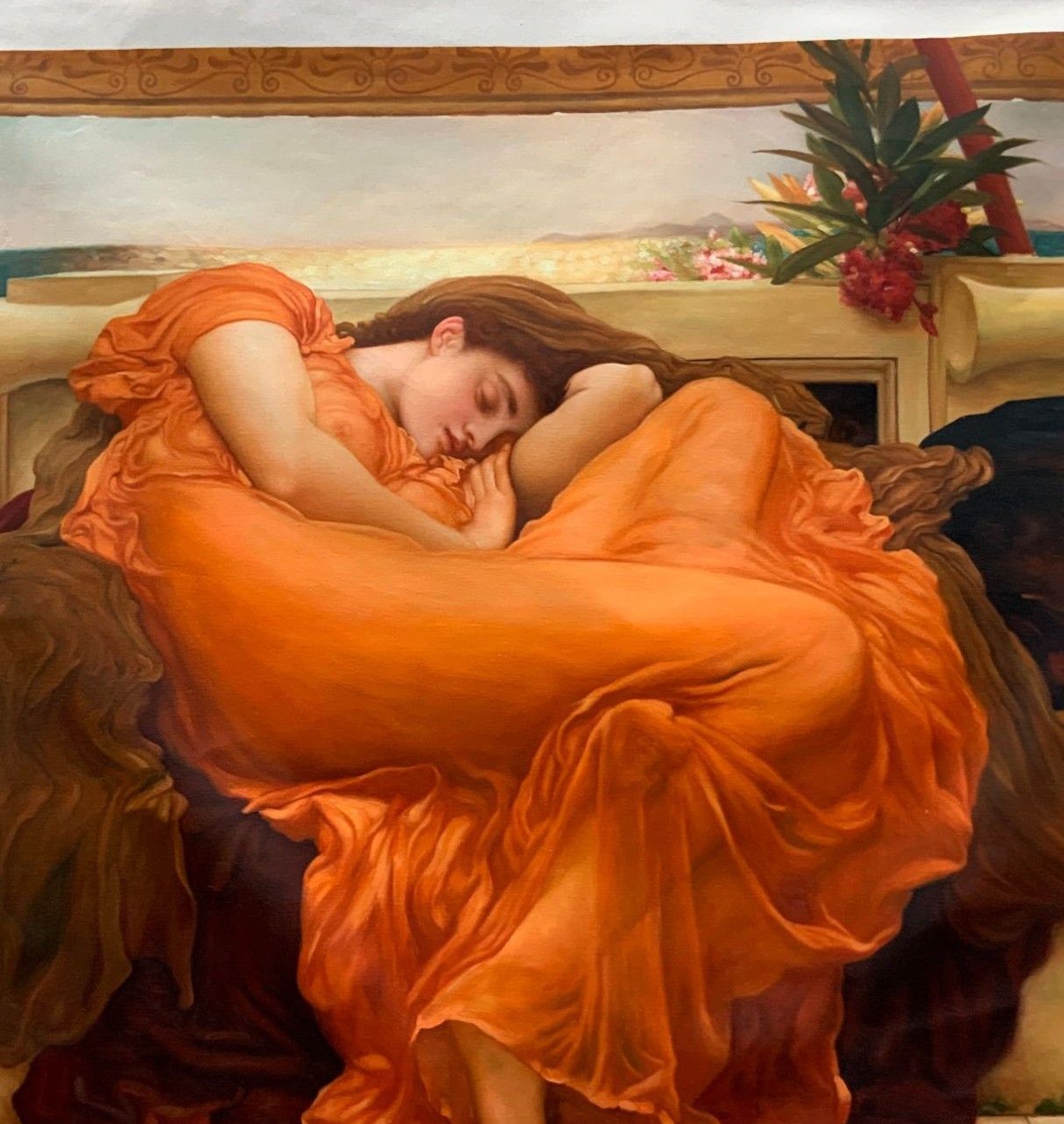 A copy after Frederic Leighton of a sleeping woman curled up in flowing orange drapery, with the sea behind her.