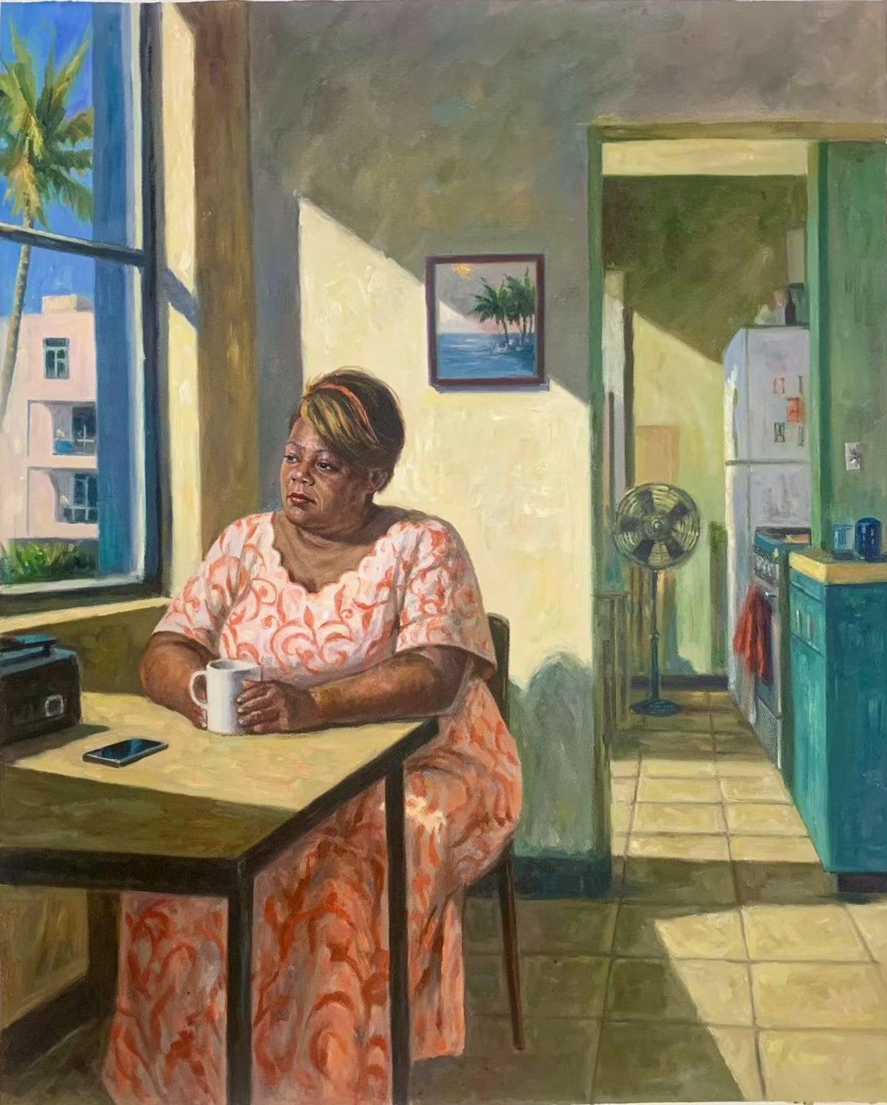 A woman in a pink dress seated at a kitchen table beside a window.