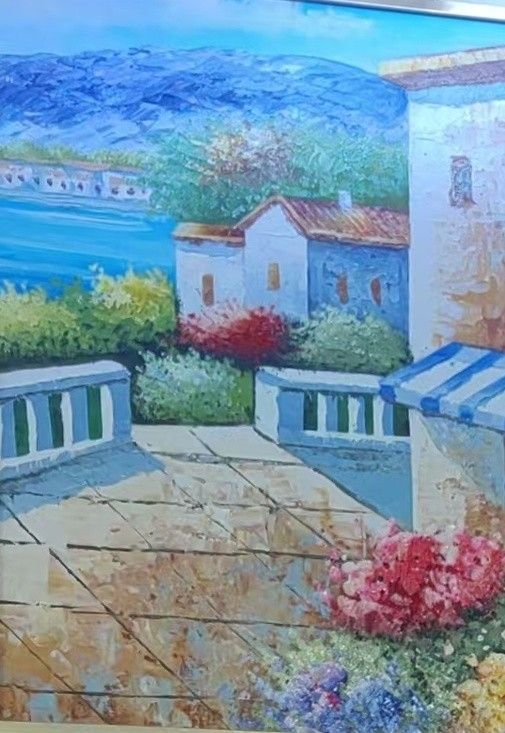 A sunlit coastal village overlooks blue water, with flowers and pale stone buildings in the foreground.